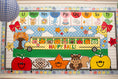 Load image into Gallery viewer, horizontal happy fall classroom banner that you get printed at Walgreens and the bus has happy fall icons peeking out of the window such as a leaf, scarecrow, acorn, and gingham apples.