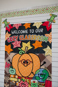 Load image into Gallery viewer, welcome to our cozy classroom tapestry with a pumpkin with glasses and leaves and fall inspired school supplies.
