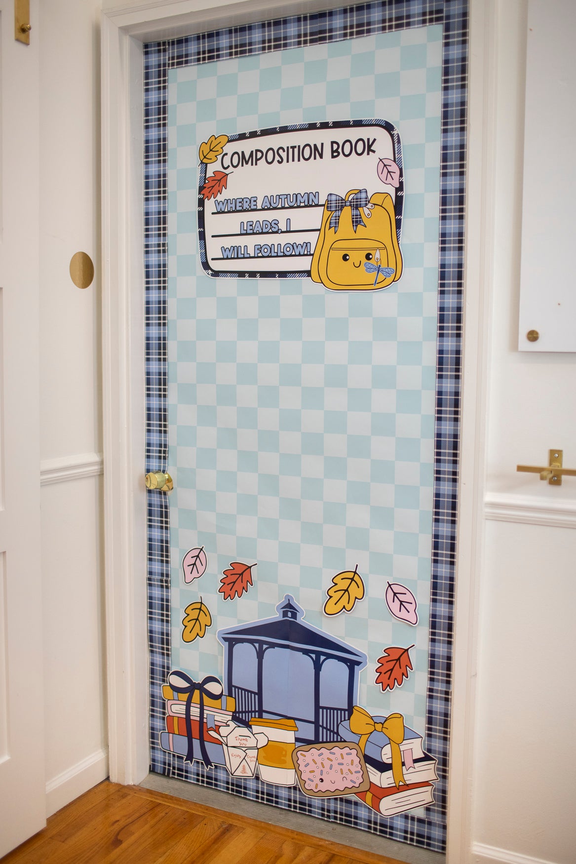 Fall Gilmore Girls Door Decor for Teachers with a blue, gold and orange theme.  There is a composition notebook label that says "where autumn leads, I will follow" as well as a gazebo, pop-tart, coffee cups, book stacks and chinese food takeout container. 