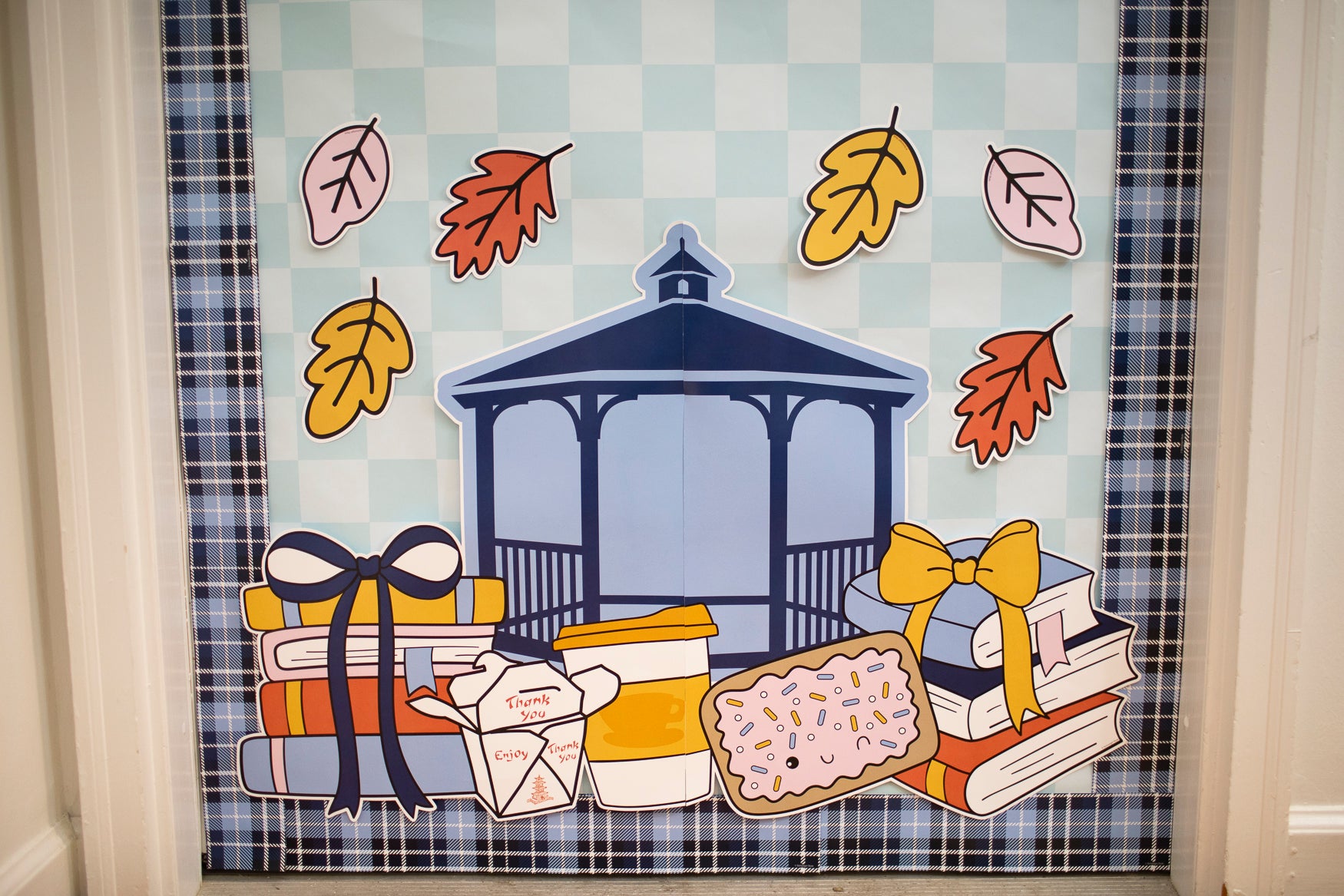 Fall Gilmore Girls Door Decor for Teachers with a blue, gold and orange theme.  There is a composition notebook label that says "where autumn leads, I will follow" as well as a gazebo, pop-tart, coffee cups, book stacks and chinese food takeout container. 