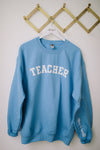 Blue Affirmation Sweatshirt that says Teacher on the front and "born to teach" on the sleeve.