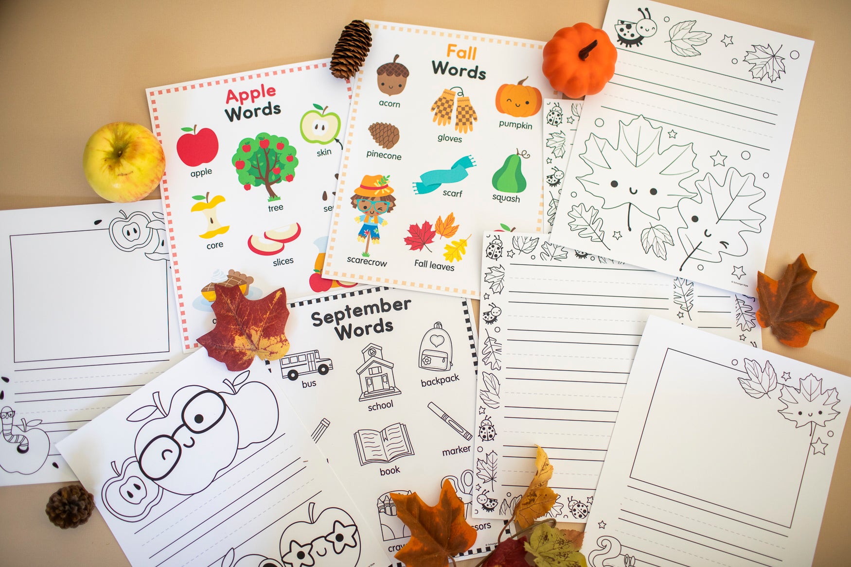 Educational worksheets and Fall themed word posters and activities on a beige surface.