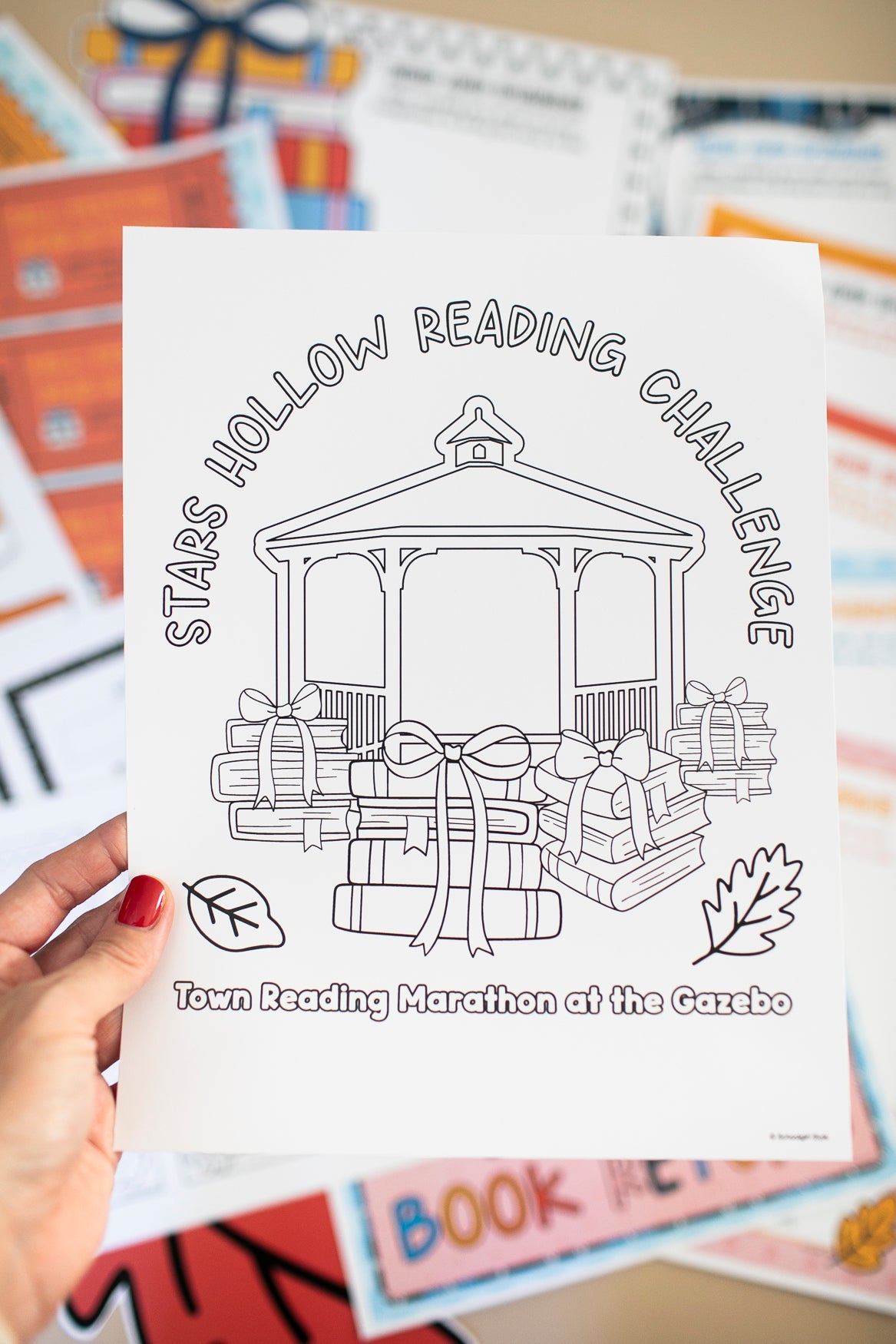 Coloring sheet for 'Stars Hollow Reading Challenge' held by a hand with colorful background
