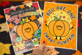 Load image into Gallery viewer, Two autumn-themed printable classroom posters held up by a hand. The left poster reads 'Welcome to our Cozy Classroom' with a smiling orange pumpkin, fall leaves, and school icons.
