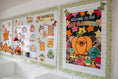 Load image into Gallery viewer, A decorated autumn-themed classroom display board on a white wall, featuring colorful fall illustrations, a pumpkin graphic, leaves, and school-themed decorations.
