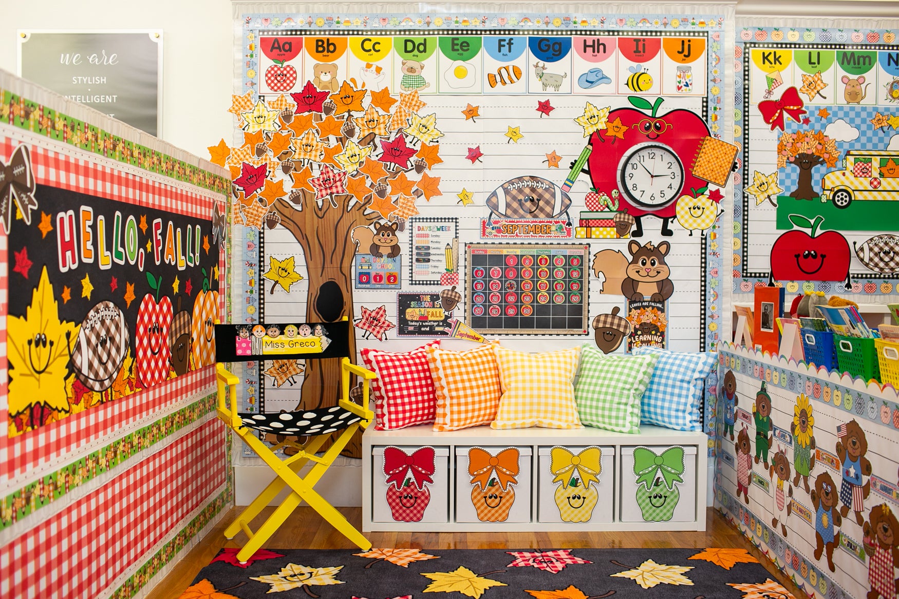 A decorated children's classroom corner with autumn-themed wall displays, colorful pillows, a tree cutout, a clock, and a bench with fall illustrations. No person or animal is present, and the scene appears to be a styled interior setup rather than a single isolated retail product.
