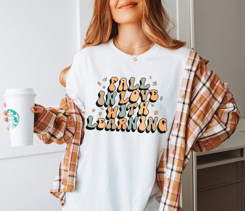 teacher t-shirt that says "fall in love with learning"